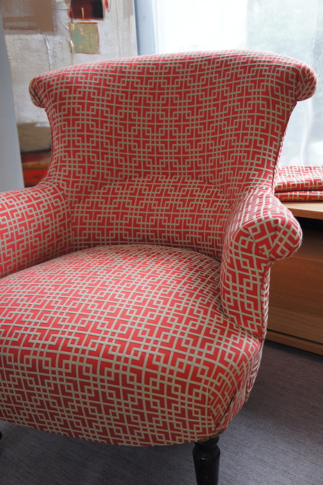 Fauteuil crapaud rouge avec un tissu géométrique marron